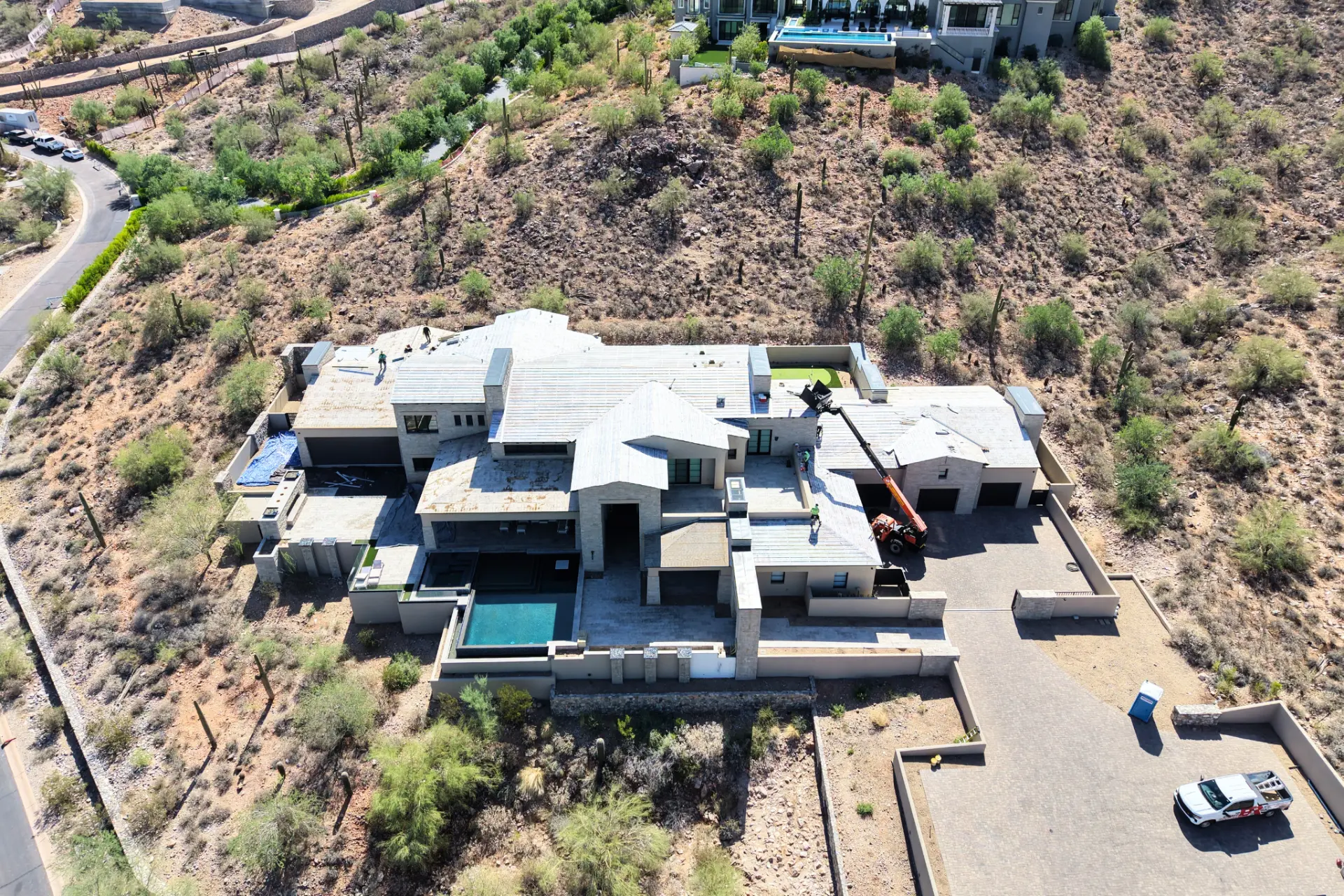 Roofing crew working on a large hillside home